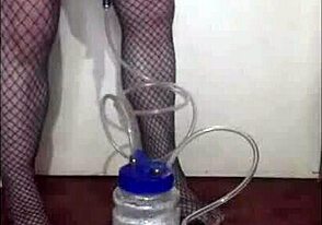 Máquina de ordeñar portátil usada en juego bisexual travesti casero con medias y tangas